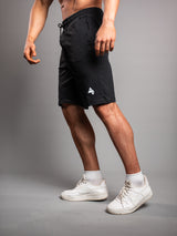 Model wearing the black AFLETE Essential Urban shorts 012, shorts three quarter view