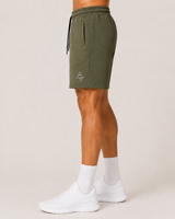 Model wearing the olive green AFLETE Core cotton shorts 018, shorts three quarter view