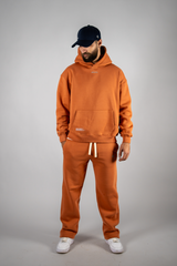 Model wearing the blaze orange AFLETE New Era tracksuit 001, full outfit front view
