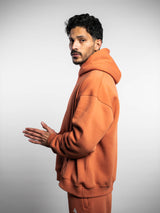 Model wearing the blaze orange AFLETE New Era tracksuit 001, full outfit side view