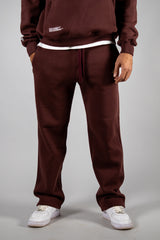 Model wearing the burgundy AFLETE New Era tracksuit 001, joggers front view