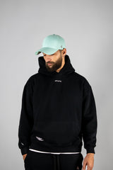 Model wearing the black AFLETE New Era hoodie 002, hoodie back view