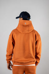 Model wearing the blaze orange AFLETE New Era hoodie 002, hoodie back view