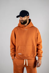 Model wearing the blaze orange AFLETE New Era hoodie 002, hoodie front view