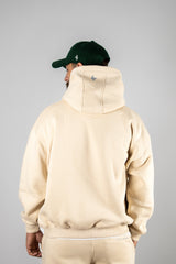 Model wearing the desert beige AFLETE New Era hoodie 002, hoodie back view