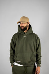 Model wearing the forest green AFLETE New Era hoodie 002, hoodie front view