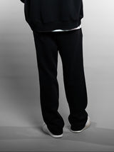 Model wearing the black AFLETE New Era joggers 003, joggers rear view