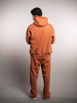 Model wearing the blaze orange AFLETE New Era joggers 003, joggers three quarter view