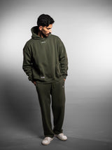 Model wearing the forest green AFLETE New Era joggers 003, joggers three quarter view