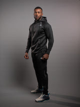 Model wearing the black AFLETE Tech Series tracksuit 005, full outfit three quarter view