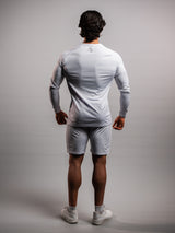 Model wearing the white AFLETE long-sleeve gym shirt 008, shirt side view