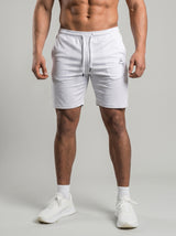 Model wearing the white AFLETE Tech Series gym shorts 010, shorts front view