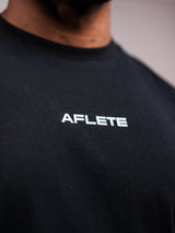 Black AFLETE Essential Urban T-shirt 011, back neck logo close up