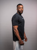 Model wearing the black AFLETE Essential Urban T-shirt 011, tshirt back view