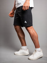 Model wearing the black AFLETE Essential Urban shorts 012, shorts dynamic side view