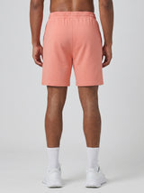Model wearing the coral pink AFLETE Essential Urban shorts 012, shorts back view