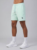 Model wearing the light mint AFLETE Essential Urban shorts 012, shorts front view