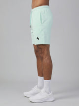 Model wearing the light mint AFLETE Essential Urban shorts 012, shorts side view