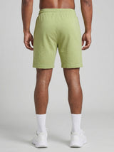 Model wearing the olive green AFLETE Essential Urban shorts 012, shorts back view