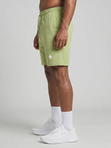 Model wearing the olive green AFLETE Essential Urban shorts 012, shorts side view