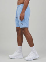 Model wearing the periwinkle blue AFLETE Essential Urban shorts 012, shorts side view
