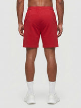 Model wearing the red AFLETE Essential Urban shorts 012, shorts back view