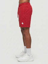 Model wearing the red AFLETE Essential Urban shorts 012, shorts side view