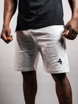 Model wearing the white AFLETE Essential Urban shorts 012, shorts dynamic side view