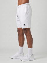 Model wearing the white AFLETE Essential Urban shorts 012, shorts side view