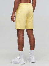 Model wearing the yellow AFLETE Essential Urban shorts 012, shorts back view