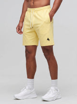 Model wearing the yellow AFLETE Essential Urban shorts 012, shorts front view