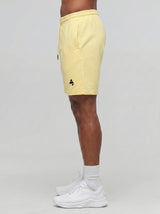 Model wearing the yellow AFLETE Essential Urban shorts 012, shorts side view