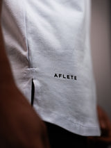 White AFLETE GYMAHOLIC gym tank top 013, hem logo close up