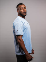 Model wearing the blue AFLETE Washed Essential oversized T-shirt 015, tshirt left side view