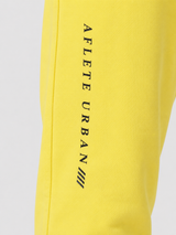 Yellow AFLETE Urban joggers 017, leg wordmark close up