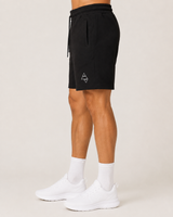 Model wearing the black AFLETE Core cotton shorts 018, shorts side view