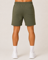 Model wearing the olive green AFLETE Core cotton shorts 018, shorts back view