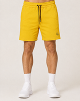Model wearing the yellow AFLETE Core cotton shorts 018, shorts front view